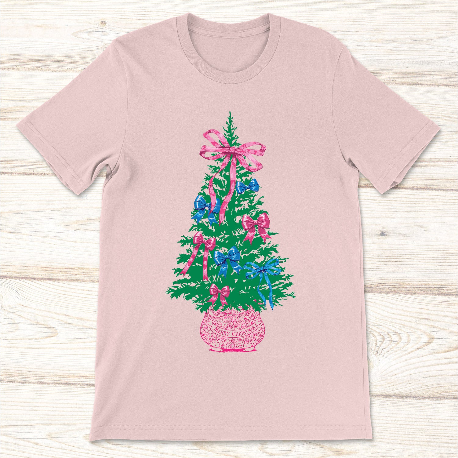 Pink short sleeved t-shirt with a Christmas tree design featuring colorful pink and blue bows.