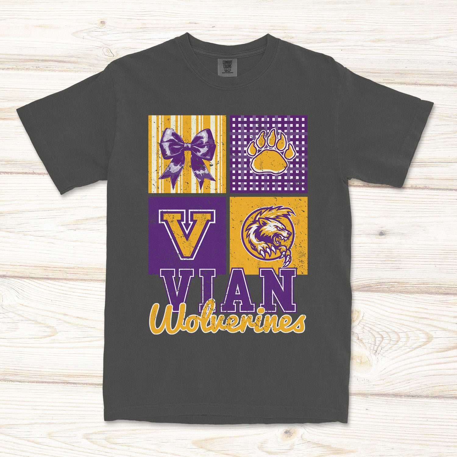 A dark gray short-sleeve t-shirt with a custom graphic print for 'Vian Wolverines'. The graphic features a 2x2 grid with purple and yellow elements: a bow, paw print, letter 'V', and a wolverine mascot logo, with 'VIAN WOLVERINES' printed below.